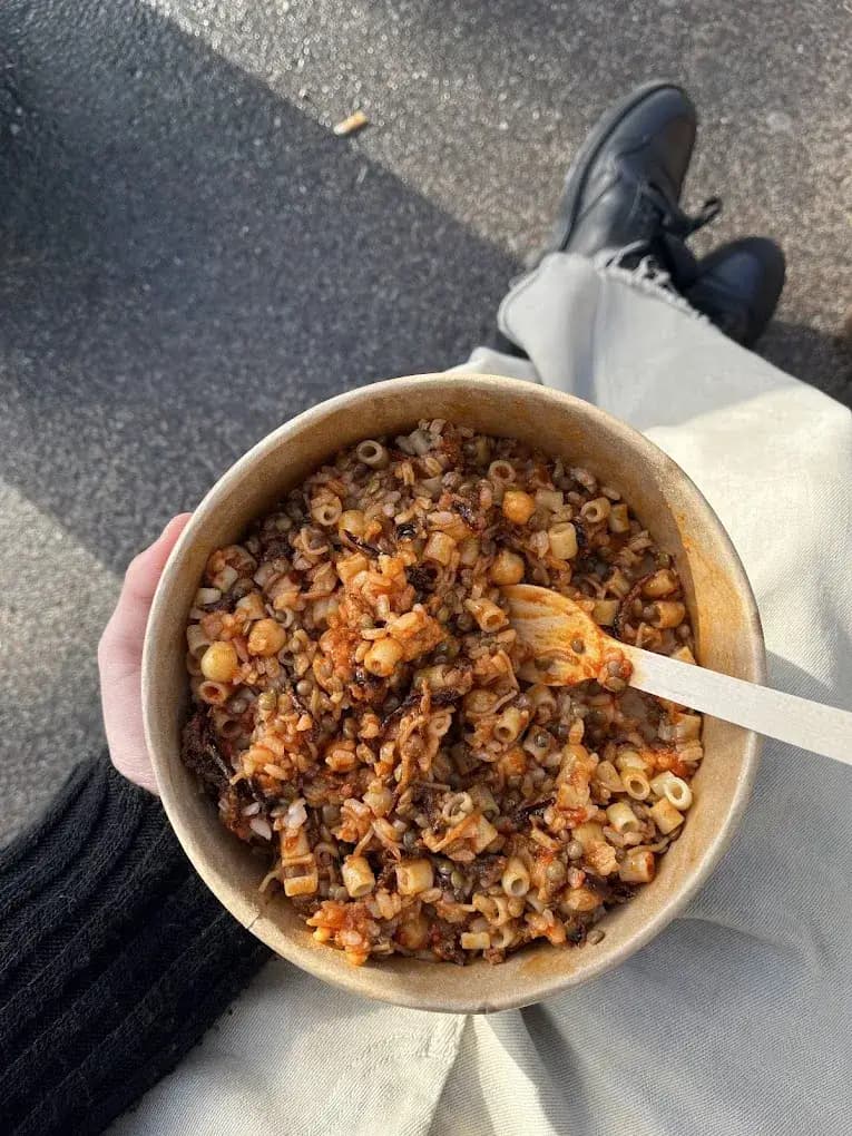 Un bol de kochari : riz, lentilles, pâtes, pois chiches, sauce tomate et oignons frits
